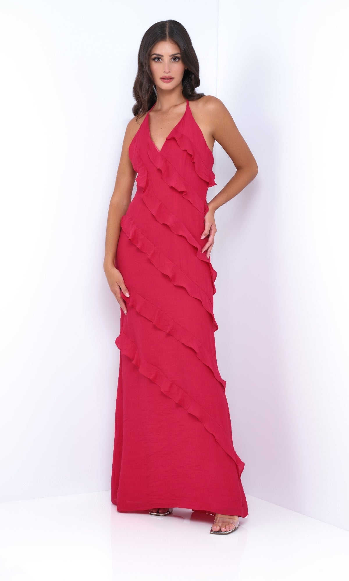 Woman in the V-Neck Halter Ruffled Long Prom Dress: Remi by Velvi—sleeveless, floor-length with diagonal ruffles—stands against a plain white background.